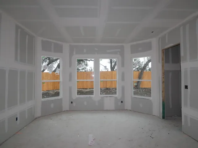 a view of an empty room with a window and fireplace