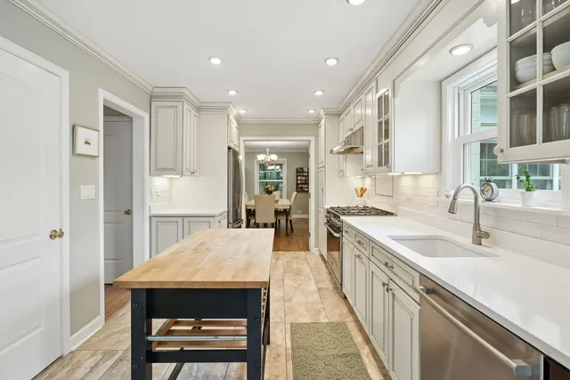 a large kitchen with kitchen island a sink stainless steel appliances and cabinets