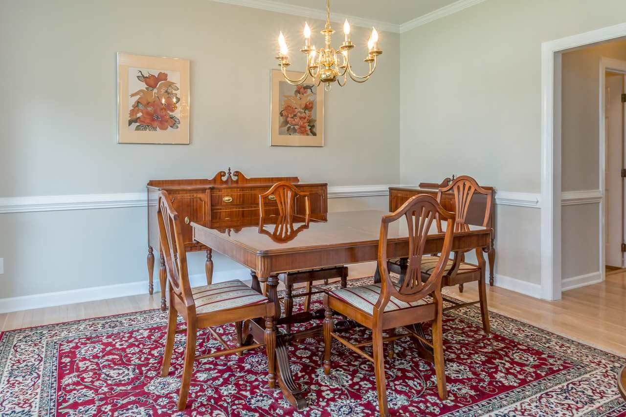 5600 Crossfield Drive Raleigh, NC 27613 - Photo 4 of 25 The freshly painted dining room features hardwood floors, a large bay window, crown molding and chair railing. Dining Room