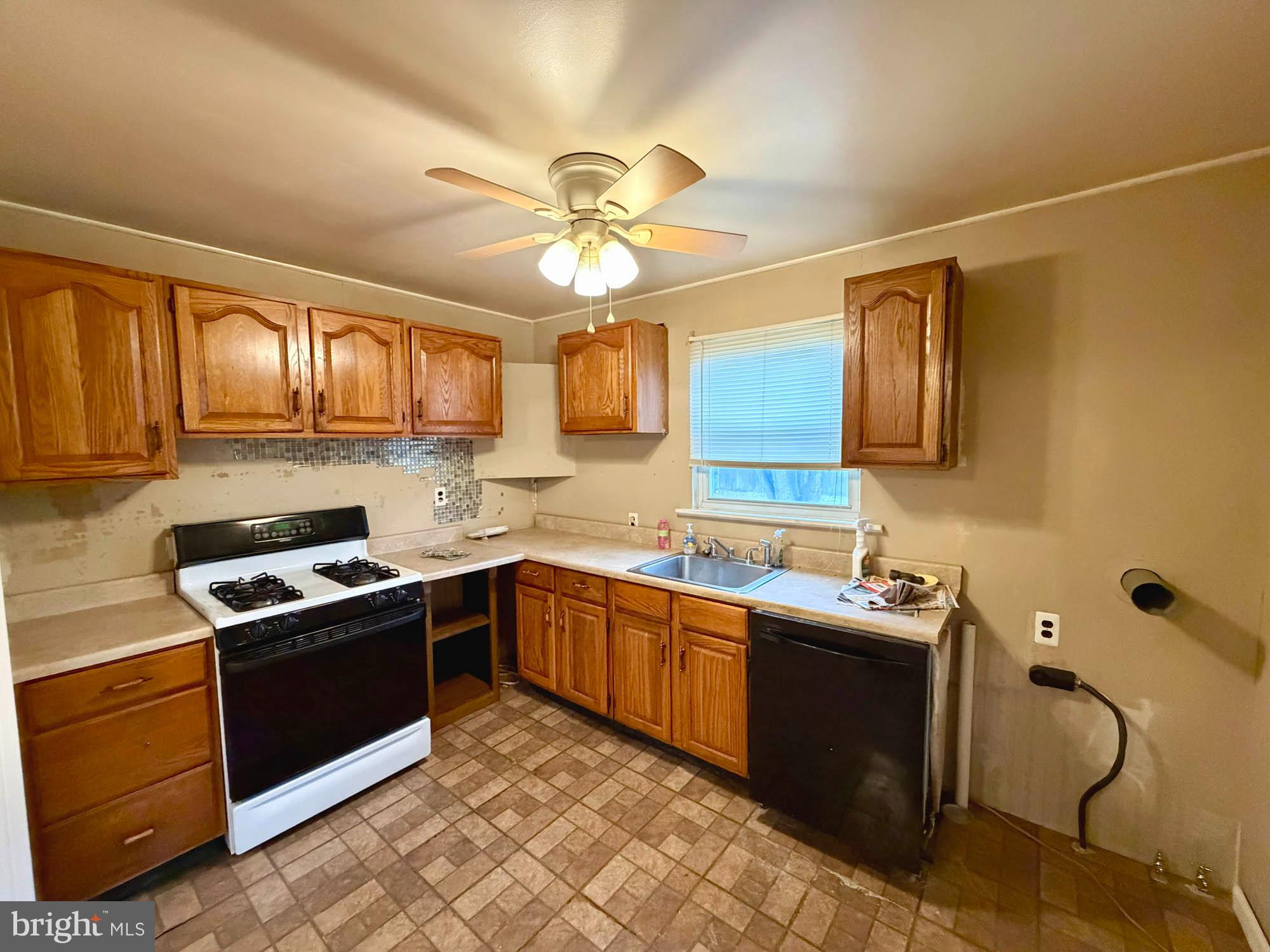 54 Riverside Road Baltimore, MD 21221 - Photo 4 of 14 a kitchen with stainless steel appliances granite countertop a sink cabinets and stove top oven