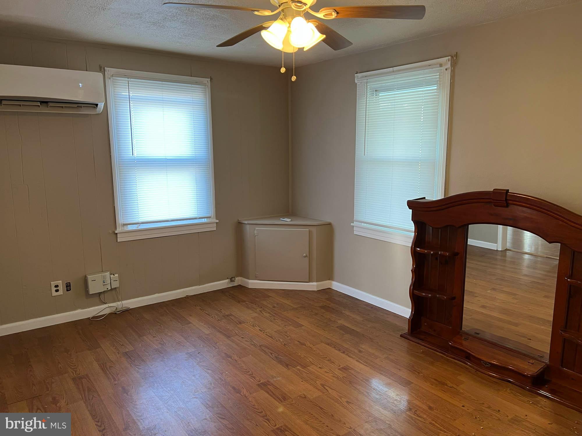 54 Riverside Road Baltimore, MD 21221 - Photo 5 of 14 an empty room with wooden floor cabinet and windows