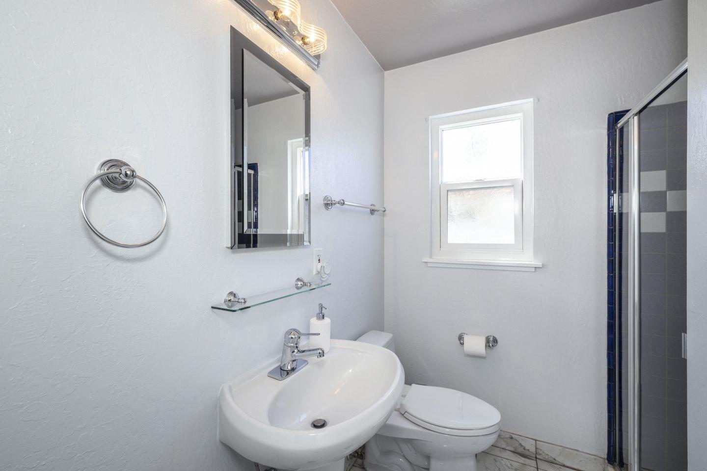 27906 Thackeray Avenue Hayward, CA 94544 - Photo 8 of 14 a bathroom with a toilet sink a mirror and vanity