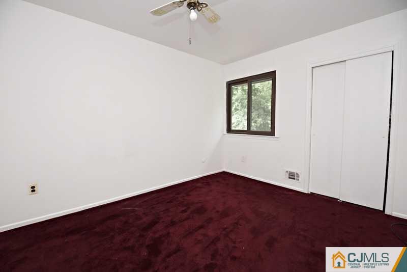 A9 Georges Road, Unit 9 Dayton, NJ 08810 - Photo 2 of 20 an empty room with a chandelier fan and windows