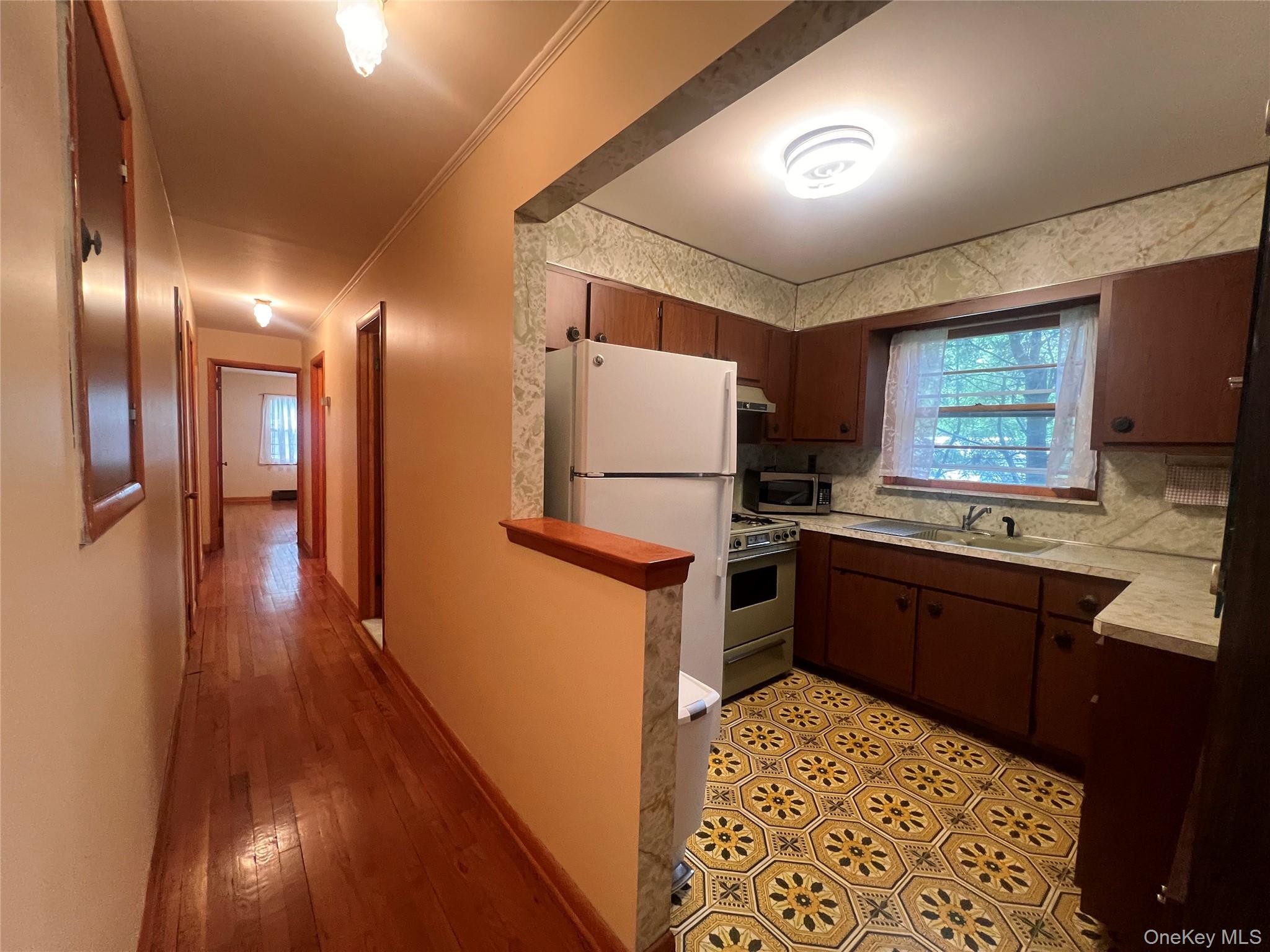 4 Beach Road, Unit G Glen Spey, NY 12737 - Photo 4 of 16 a kitchen with stainless steel appliances granite countertop a refrigerator a sink dishwasher a stove and white countertops with wooden floor