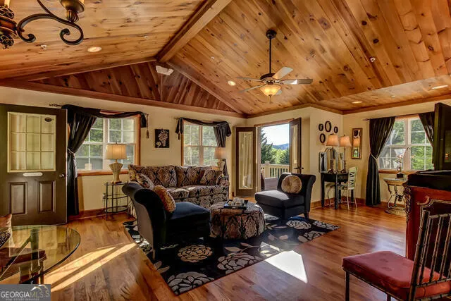 a dining room with furniture a chandelier and wooden floor