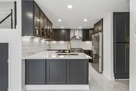 a kitchen with kitchen island a sink stainless steel appliances and cabinets