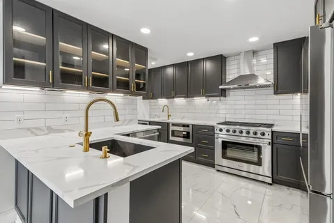 a kitchen with stainless steel appliances granite countertop a sink and stove