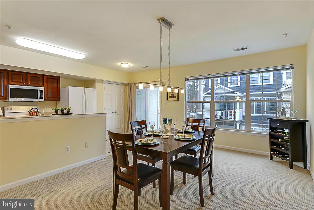 11344 King George Drive, Unit 5 Silver Spring, MD 20902 - Photo 12 of 30 a dining room with furniture a window and kitchen view