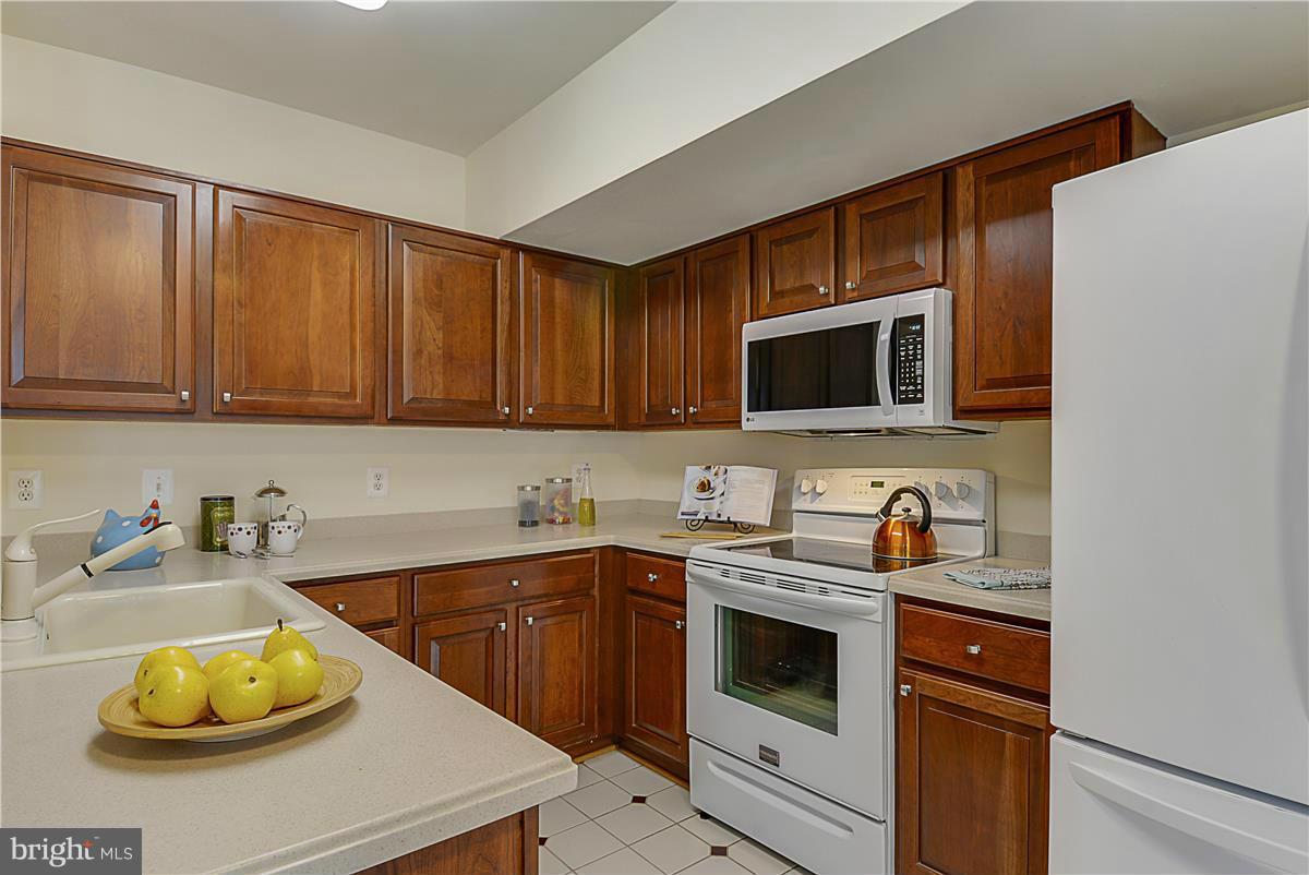 11344 King George Drive, Unit 5 Silver Spring, MD 20902 - Photo 14 of 30 a kitchen with a sink a stove and cabinets