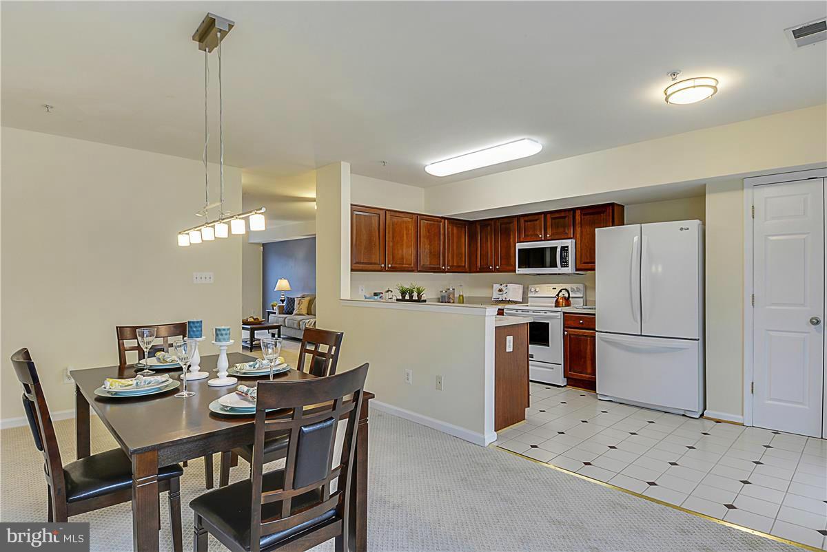 11344 King George Drive, Unit 5 Silver Spring, MD 20902 - Photo 16 of 30 a kitchen with white cabinets and stainless steel appliances