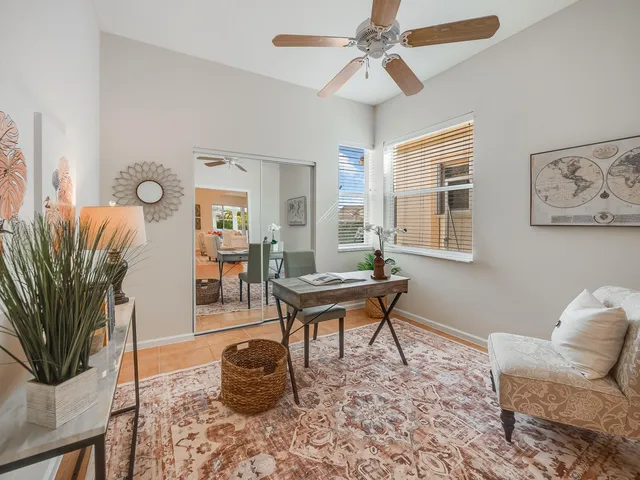 a bedroom with a bed window with table and chair