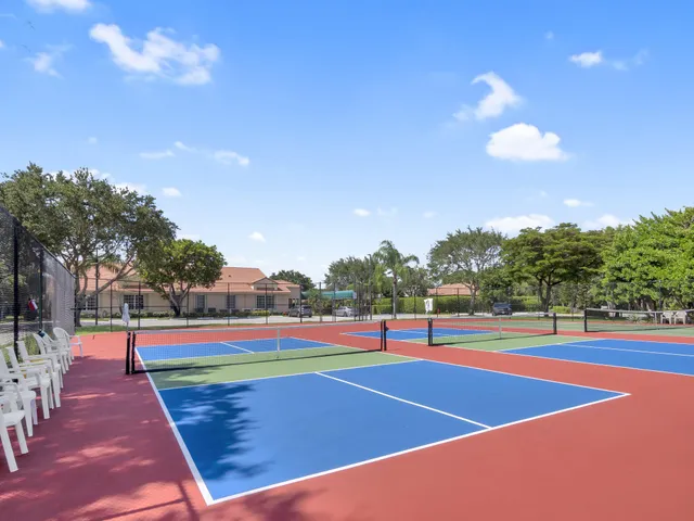 a view of a tennis ground with large trees