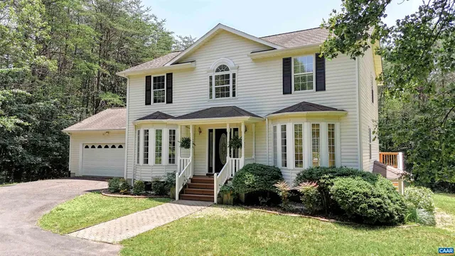 a view of a white house with a yard and plants