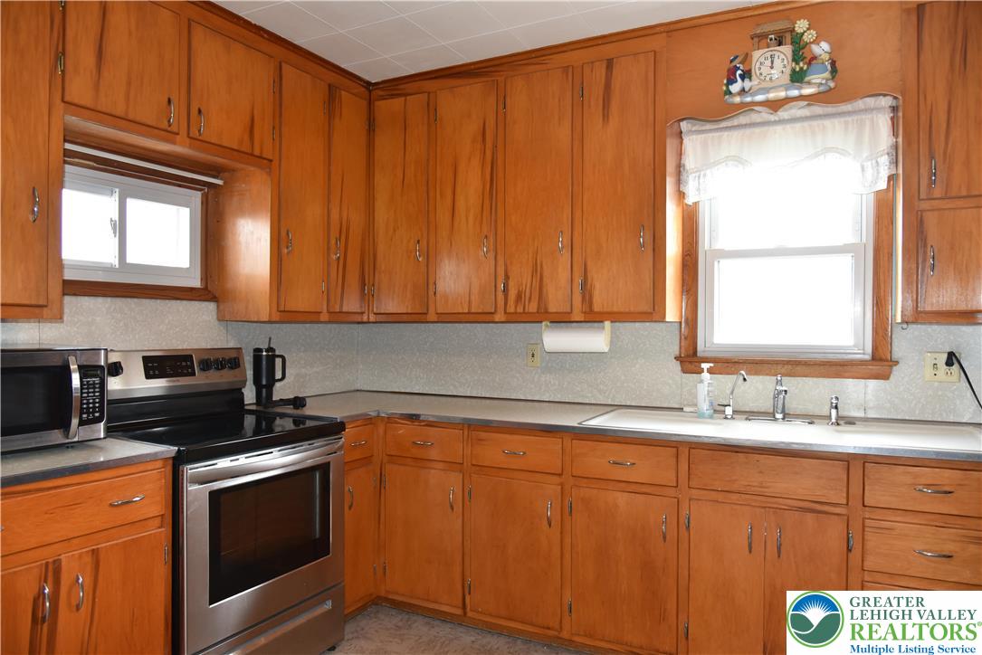 238 Grim Road Kutztown, PA 19530 - Photo 3 of 27 a kitchen with stainless steel appliances granite countertop a sink a stove cabinets and a window
