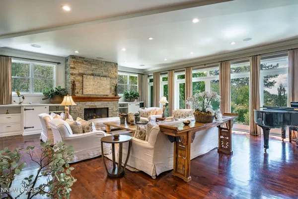 a living room with fireplace furniture and a large window