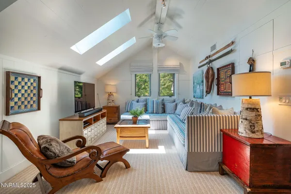 a living room with furniture a chandelier and a flat screen tv