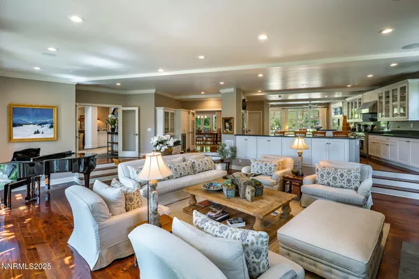 a living room with furniture kitchen view and a large window