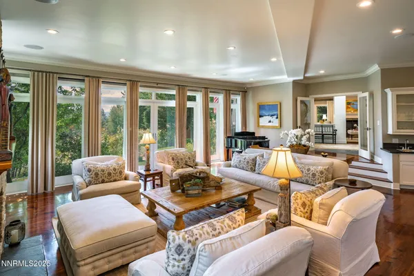 a living room with furniture and floor to ceiling windows