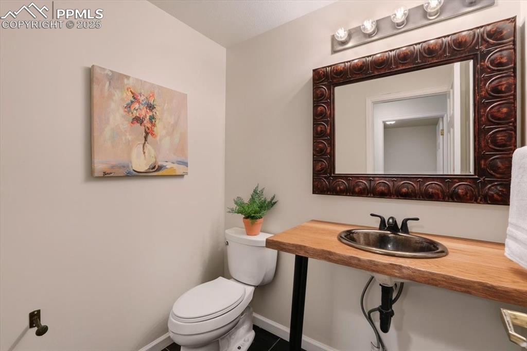 395 Cardiff Circle Colorado Springs, CO 80906 - Photo 14 of 31 a bathroom with a toilet a sink and mirror