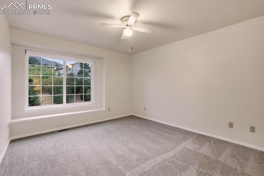 395 Cardiff Circle Colorado Springs, CO 80906 - Photo 21 of 31 an empty room with a window and a ceiling fan