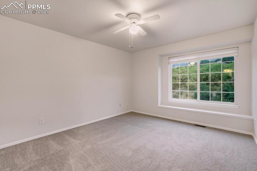 395 Cardiff Circle Colorado Springs, CO 80906 - Photo 22 of 31 an empty room with a window and a ceiling fan