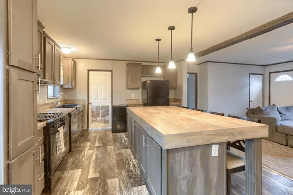 a kitchen with a table chairs refrigerator and wooden floor