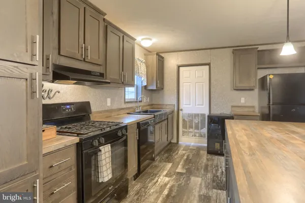 a kitchen with stainless steel appliances granite countertop a stove a sink and a refrigerator