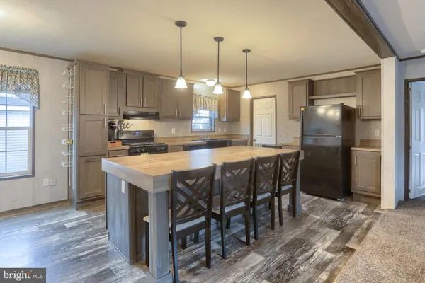 a kitchen with kitchen island a refrigerator a stove a sink and a refrigerator