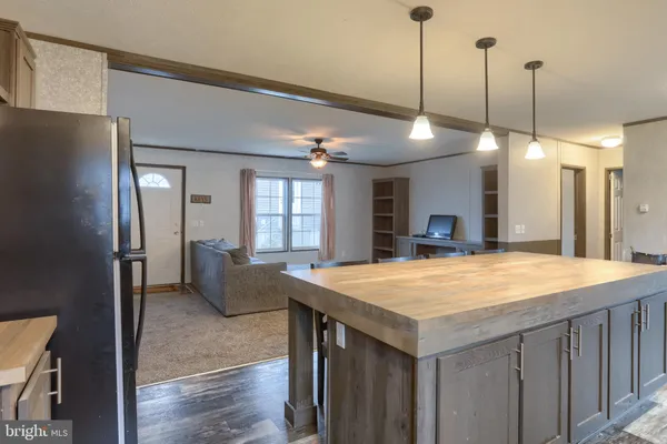 a room with a chandelier and a kitchen island