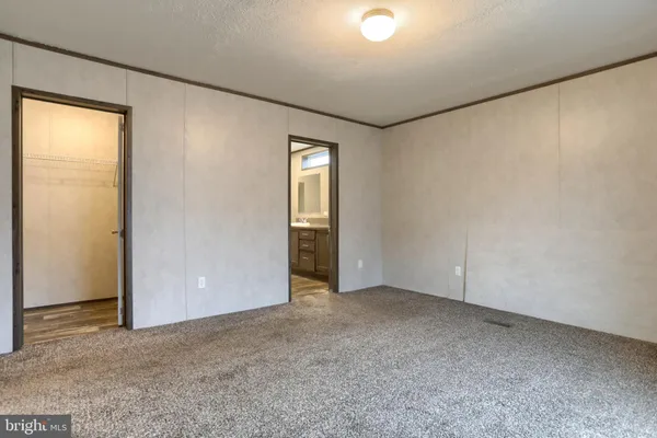an empty room with closet and windows