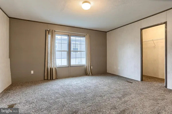 an empty room with windows and closet