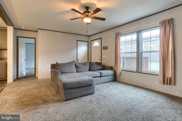 a living room with furniture and a ceiling fan