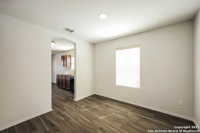 an empty room with wooden floor and a window