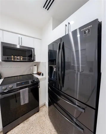 a kitchen with appliances a sink and cabinets