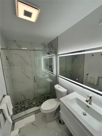 a bathroom with a sink toilet and mirror