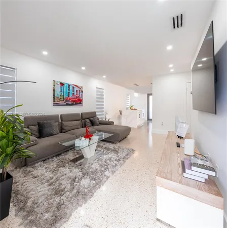 a white kitchen with a sink a stove and a potted plant