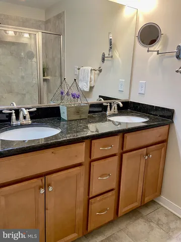 a bathroom with a granite countertop sink and a mirror