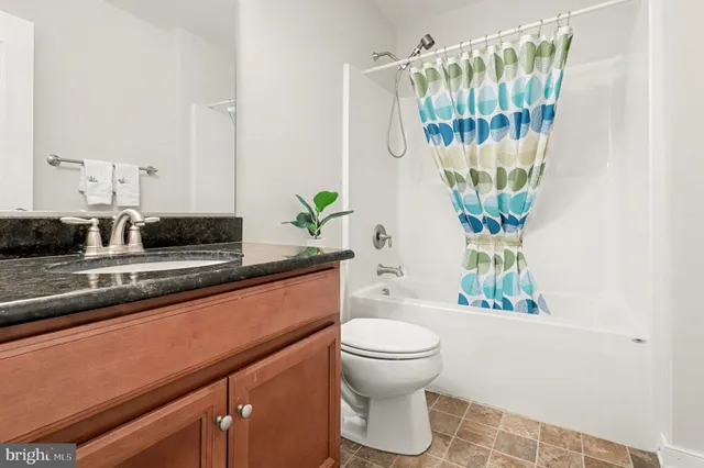 a living room with a couch and a potted plant