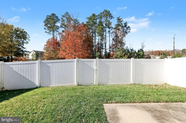 a view of backyard with potted plants and wooden fence