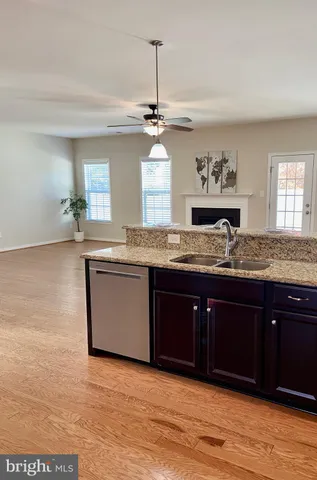 a kitchen with stainless steel appliances granite countertop a sink cabinets and wooden floor