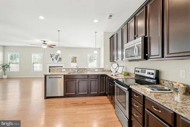 a kitchen with stainless steel appliances granite countertop a sink stove and cabinets