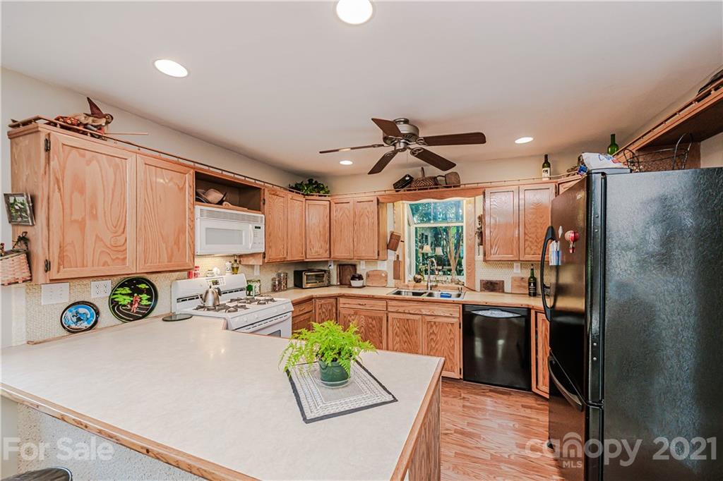 23055 Point Clear Drive, Unit 5 Tega Cay, SC 29708 - Photo 14 of 45 a kitchen with kitchen island granite countertop a sink a counter top space appliances and cabinets