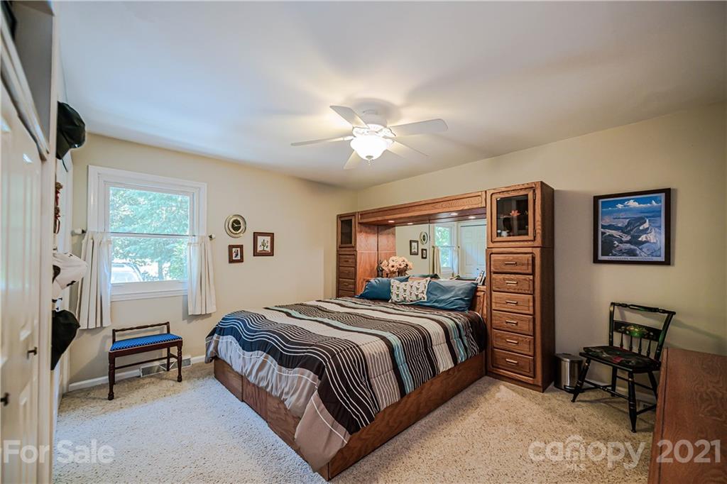23055 Point Clear Drive, Unit 5 Tega Cay, SC 29708 - Photo 21 of 45 a bedroom with a bed and a chandelier