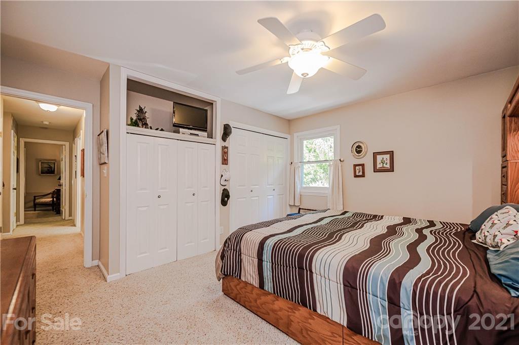 23055 Point Clear Drive, Unit 5 Tega Cay, SC 29708 - Photo 24 of 45 a bedroom with a large bed and a chandelier
