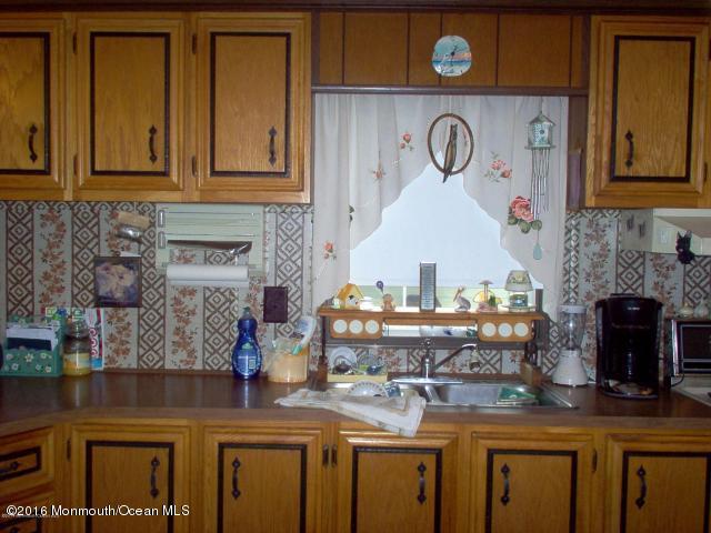 113 Village Road Morganville, NJ 07751 - Photo 4 of 7 a kitchen with stainless steel appliances granite countertop a stove and a microwave
