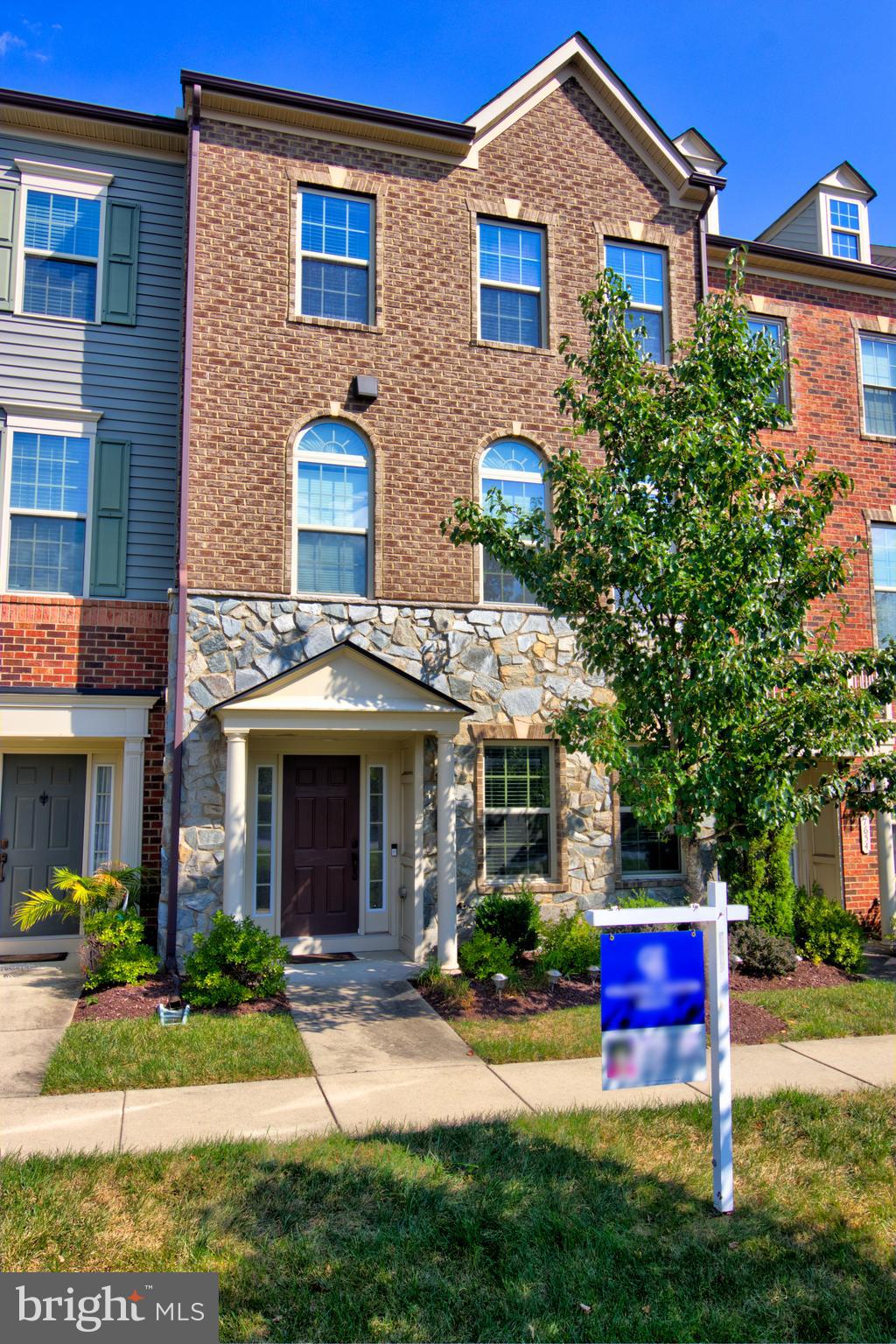 a front view of a house with yard and green space