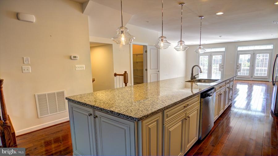 7652 Telamon Way Hanover, MD 21076 - Photo 13 of 34 a kitchen with stainless steel appliances granite countertop a sink a refrigerator and a wooden floor