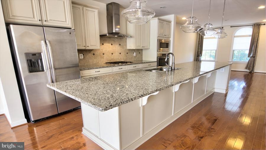 7652 Telamon Way Hanover, MD 21076 - Photo 14 of 34 a kitchen with stainless steel appliances granite countertop a sink a stove and a refrigerator