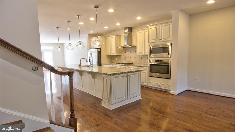 7652 Telamon Way Hanover, MD 21076 - Photo 16 of 34 a kitchen with stainless steel appliances granite countertop a sink a stove and a refrigerator