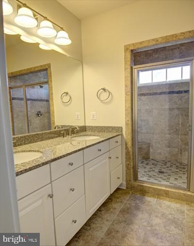 7652 Telamon Way Hanover, MD 21076 - Photo 27 of 34 a bathroom with a granite countertop sink a mirror and a shower